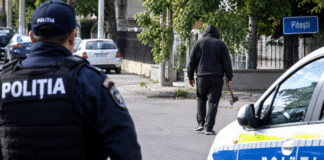 Bărbat cu toporul în mână, filmat pe o stradă din Pitești. Polițiștii îl caută